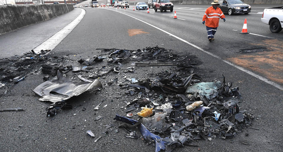 Charred debris sits on the Ipswich Motorway after a fatal collision that claimed the lives of four people.