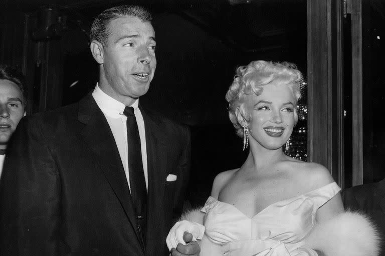 En esta foto de archivo del 2 de junio de 1955, la actriz Marilyn Monroe, a la derecha, con un glamoroso vestido de noche, con Joe DiMaggio, llega al teatro.