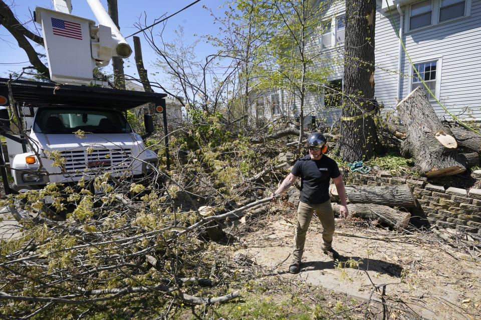 Austin Even, of Independence, Iowa, clears branches from in front of a home, Friday, April 30, 2021, in Cedar Rapids. A rare storm called a derecho plowed through the city of 130,000 last August with 140 mph winds and left behind a jumble of branches, downed powerlines and twisted signs. Now, city officials, businesses and nonprofit groups have teamed up with ambitious plans to somehow transform what is now a city of stumps back into the tree-covered Midwestern oasis along the Cedar River. (AP Photo/Charlie Neibergall)