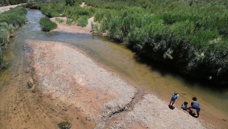 A woman and her children play in the Virgin River on June 10, 2022. The Washington County Water Conservancy District recently published a 20-year plan to guide the county’s water use.
