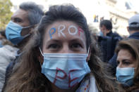 A teacher has her forehead painted withe the word Teacher during a demonstration Sunday Oct. 18, 2020 in Paris. Demonstrations around France have been called in support of freedom of speech and to pay tribute to a French history teacher who was beheaded near Paris after discussing caricatures of Islam's Prophet Muhammad with his class. Samuel Paty was beheaded on Friday by a 18-year-old Moscow-born Chechen refugee who was shot dead by police. (AP Photo/Michel Euler)