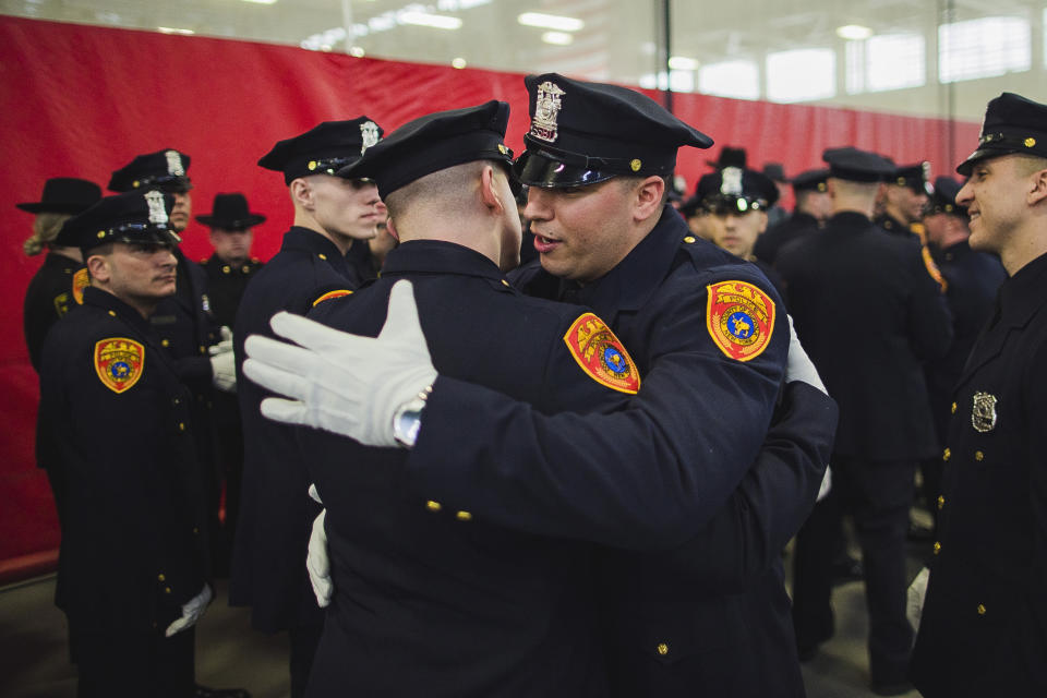 Matias Ferreira, center, hugs his colleague as they prepare to march during their graduation from the Suffolk County Police Department Academy at the Health, Sports and Education Center in Suffolk, N.Y., Friday, March 24, 2017. Ferreira, a former U.S. Marine Corps lance corporal who lost his legs below the knee when he stepped on a hidden explosive in Afghanistan in 2011, is joining a suburban New York police department. The 28-year-old graduated Friday from the Suffolk County Police Academy on Long Island following 29 weeks of training. (AP Photo/Andres Kudacki)