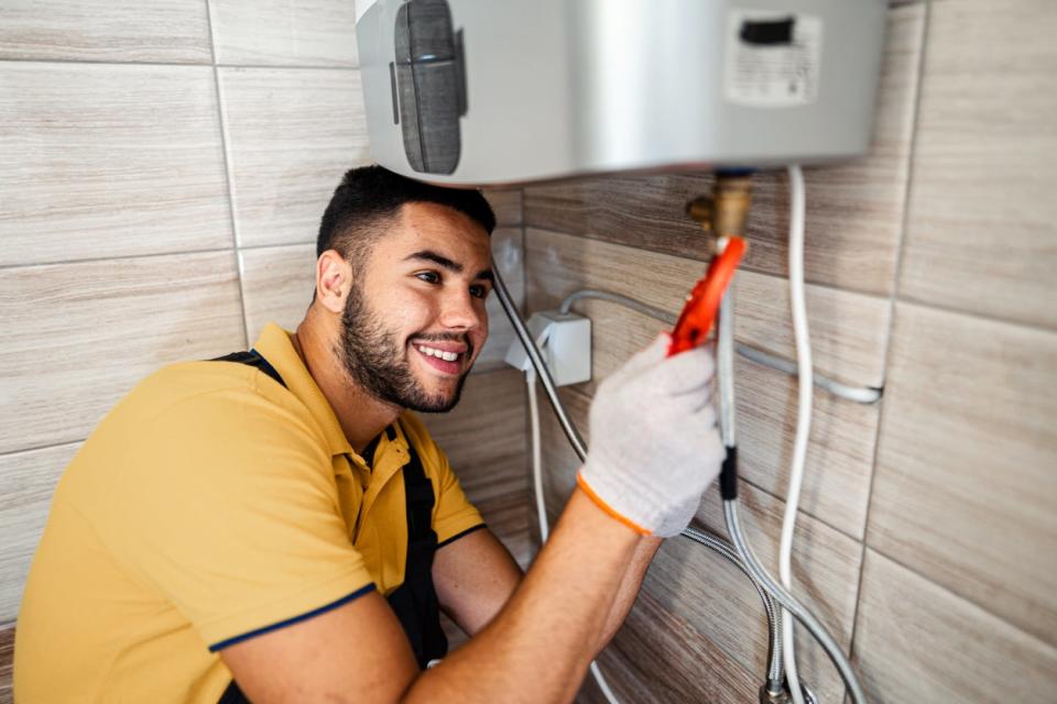 Young man installing a tankless water heater.