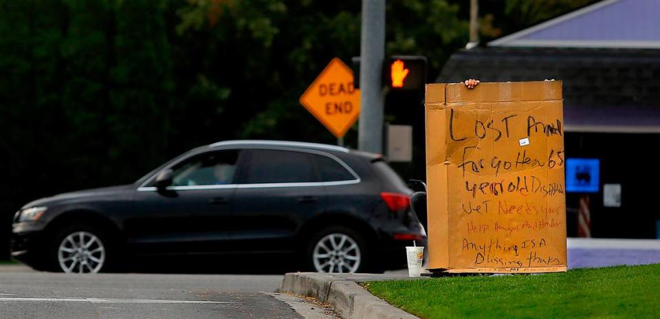 A homeless man holds a sign in September 2022 at the entrance to the WinCo grocery store on West Clearwater Avenue in Kennewick.