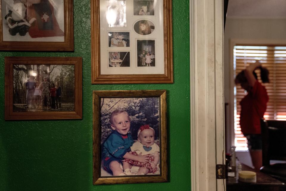 Pictures of Army Sgt. Cody Bowman, bottom left, decorate the walls of Barbie Rohde's home in Flint, Texas, as she stands in her bedroom Friday, June 9, 2023. One day, she got home from work waiting tables. She heard a car, looked out the window and saw men in military dress uniforms heading toward her house. “Your son Sgt. Cody Bowman died of a self-inflicted gunshot wound,” they said. For the rest of the day, Rohde sat on the floor and screamed. (AP Photo/David Goldman)