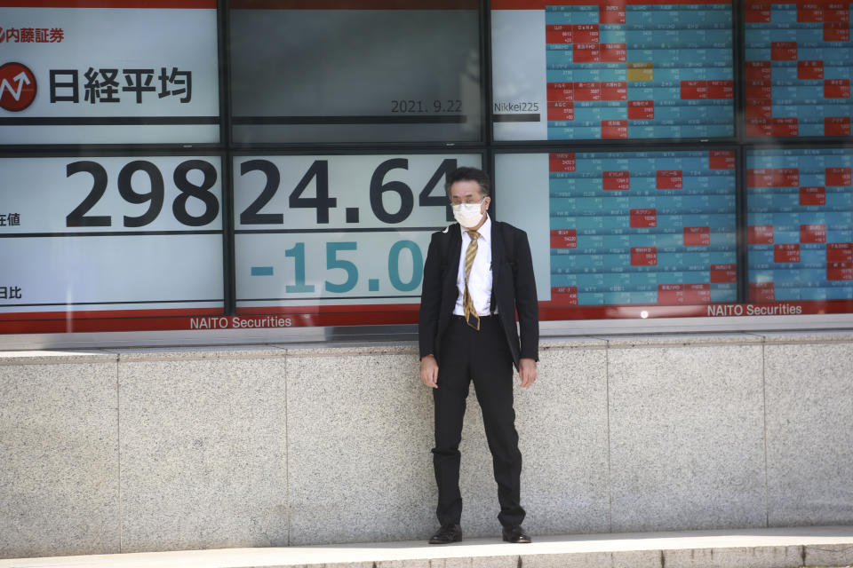 A man stands in front of an electronic stock board of a securities firm in Tokyo, Wednesday, Sept. 22, 2021. Asian shares were mostly lower on Wednesday after major indexes ended mixed on Wall Street. (AP Photo/Koji Sasahara)