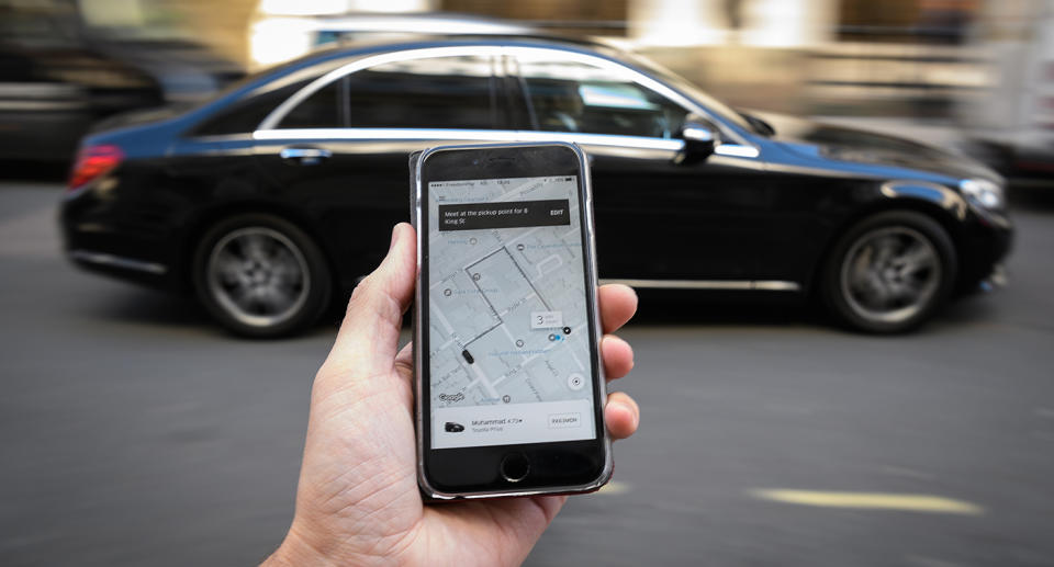 a phone displays the Uber ride-hailing app