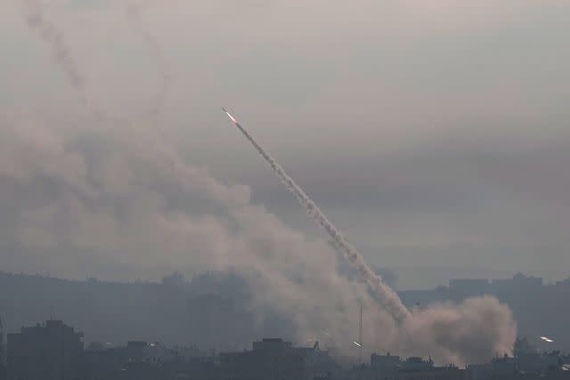 <p>Momen Faiz/NurPhoto via Getty </p> Palestinian militants fire missiles at Israel on October 7, 2023