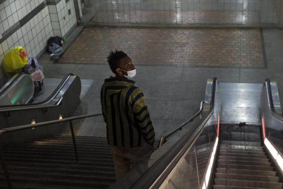 Homeless people wait for the gates to open at 7th Street Metro station.