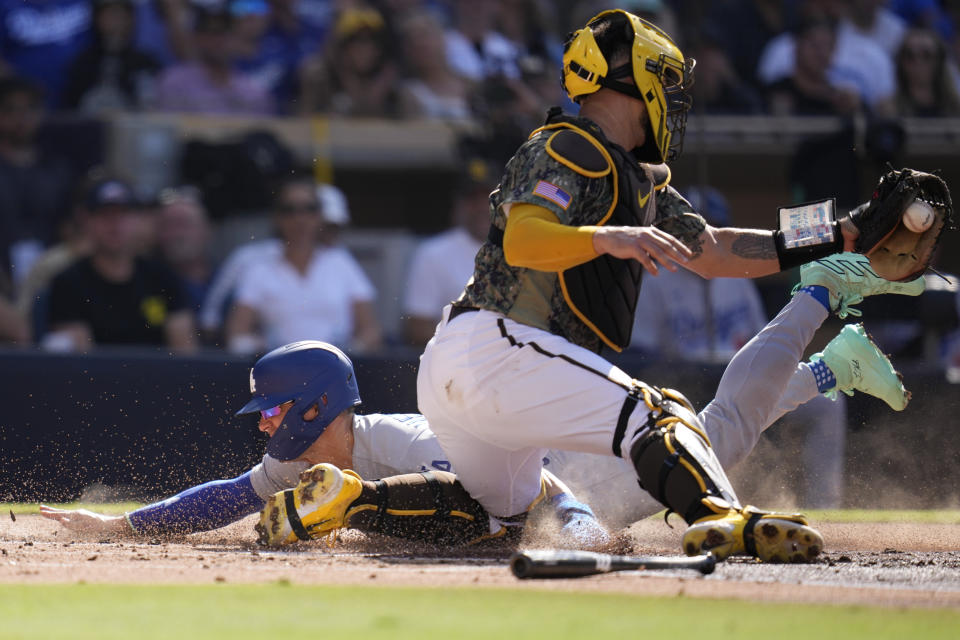Los Angeles Dodgers' Kiké Hernandez, left, slides in to home, scoring off a sacrifice bunt by Austin Barnes as San Diego Padres catcher Gary Sanchez is late with the tag during the second inning of a baseball game Sunday, Aug. 6, 2023, in San Diego. (AP Photo/Gregory Bull)