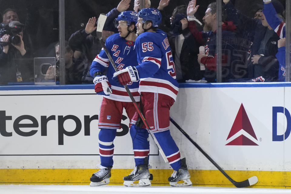 New York Rangers' Artemi Panarin, left, celebrates after his goal with Ryan Lindgren during the second period in Game 1 of an NHL hockey Stanley Cup first-round playoff series against the Washington Capitals, Sunday, April 21, 2024, in New York. (AP Photo/Seth Wenig)