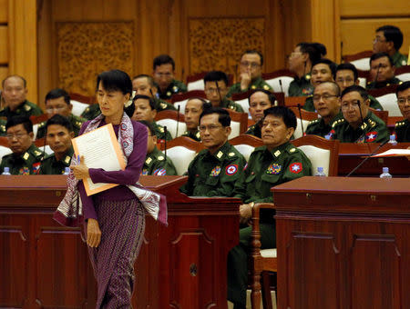 FILE PHOTO: Pro-democracy leader Aung San Suu Kyi walks to take an oath at the lower house of parliament in Naypyitaw May 2, 2012. REUTETS/Soe Zeya Tun/File Photo