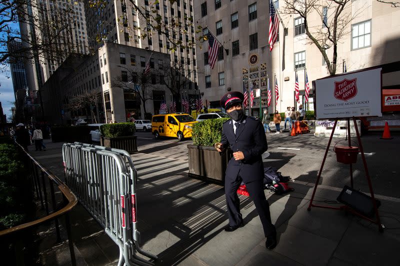 A Salvation Army member wearing a protective mask sings and dances at Rockefeller Center as the spread of the coronavirus disease (COVID-19) continues, in New York City