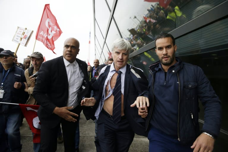 Director of Air France in Orly, Pierre Plissonnier, nearly shirtless, runs away from demonstrators after several hundred employees invaded the offices of Air France on October 5, 2015