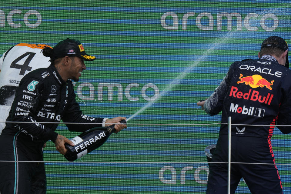 Third placed Mercedes driver Lewis Hamilton of Britain sprays champagne on winner Red Bull driver Max Verstappen of the Netherlands during the British Formula One Grand Prix race at the Silverstone racetrack, Silverstone, England, Sunday, July 9, 2023. (AP Photo/Luca Bruno)