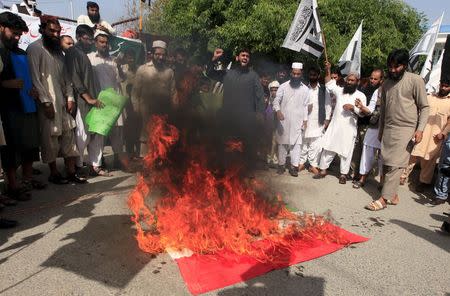 Supporters of the Jamaat-ud-Dawa organization burn an Indian flag during a demonstration in Islamabad April 17, 2015. REUTERS/Faisal Mahmood