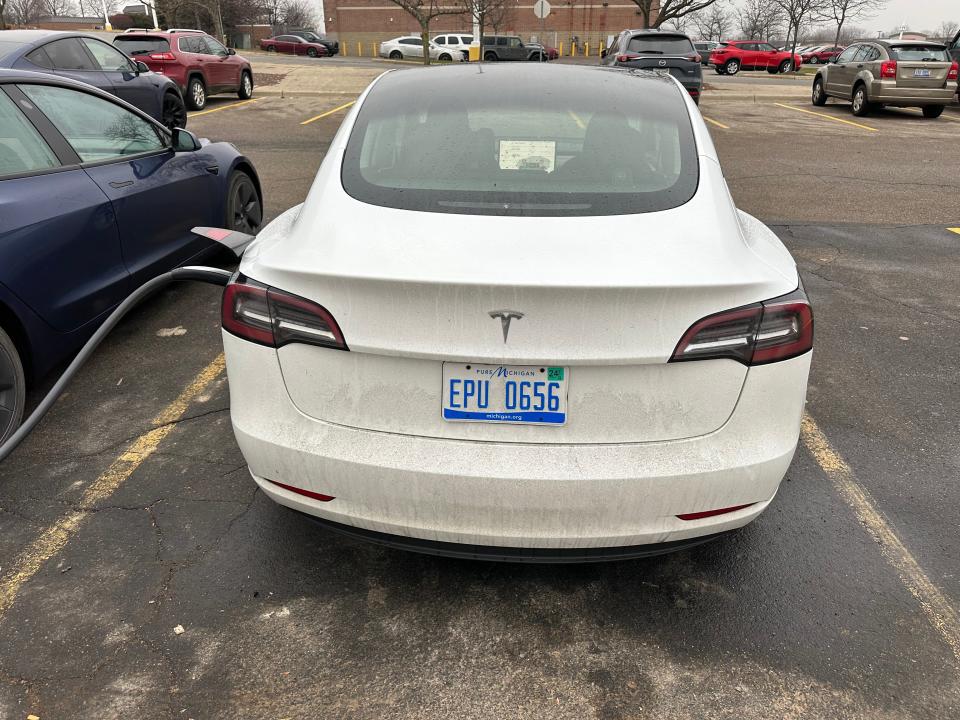 Tesla Model 3 plugged into a Supercharger