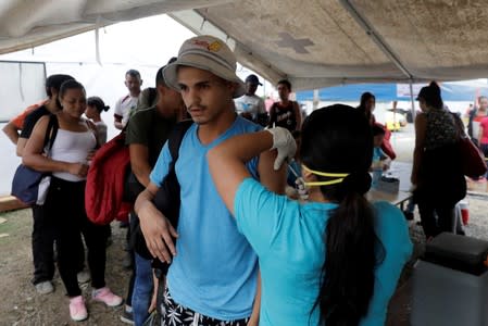A Venezuelan migrant receives a vaccination at the Binational Border Service Center of Peru, in Tumbes
