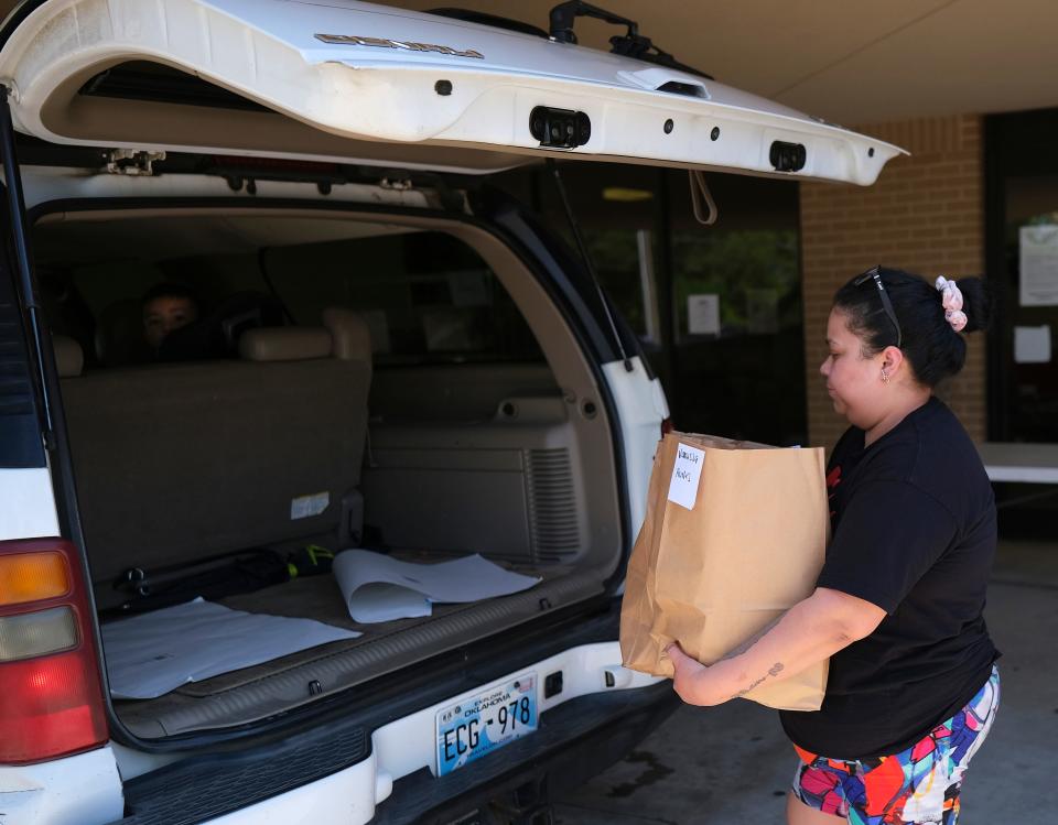 Vanessa Aviles loads a sack of supplies, including baby formula, Friday, May 13, 2022, at Infant Crisis Services during a baby formula shortage.