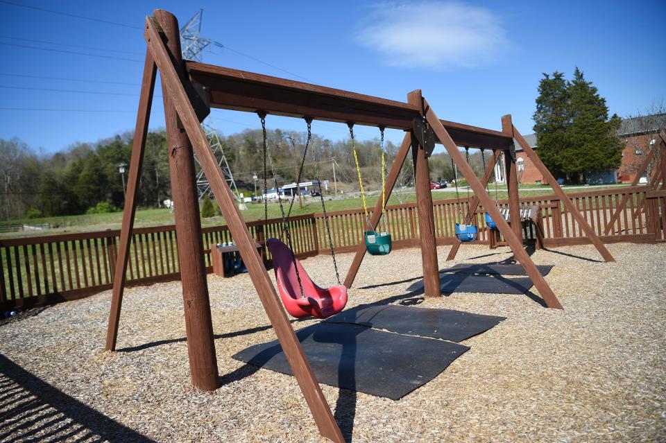 Mats were placed under the swings to prevent coal ash from being brought to the surface as children's feet dug into the exposed dirt.