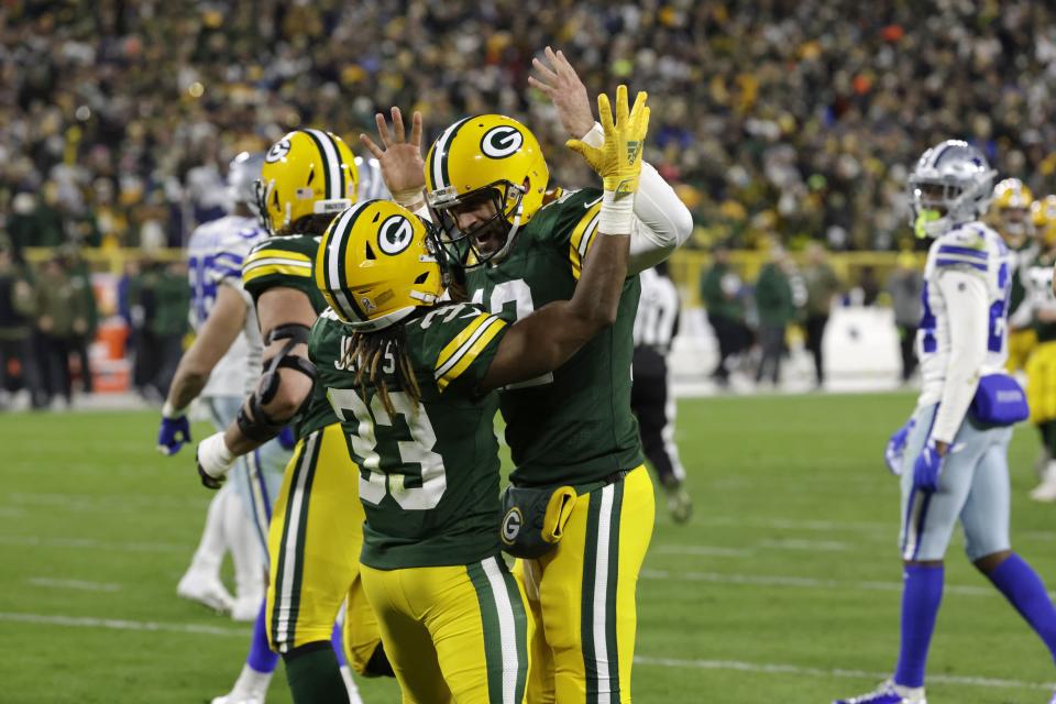 Aaron Jones (33) and Green Bay Packers quarterback Aaron Rodgers, center right, celebrate after Jones scored a touchdown during the first half of an NFL football game against the Dallas Cowboys Sunday, Nov. 13, 2022, in Green Bay, Wis. (AP Photo/Mike Roemer)