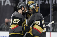 Vegas Golden Knights goaltender Marc-Andre Fleury (29) and defenseman Shea Theodore (27) celebrate after the Vegas Golden Knights defeated the Montreal Canadiens in Game 1 of an NHL hockey Stanley Cup semifinal playoff series Monday, June 14, 2021, in Las Vegas. (AP Photo/John Locher)