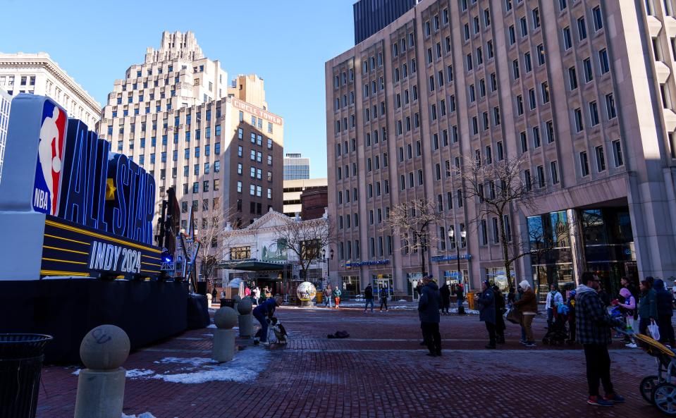 Fans congregate Sunday, Feb. 18, 2024, near a large NBA All-Star sign sitting along Monument Circle in downtown Indianapolis.