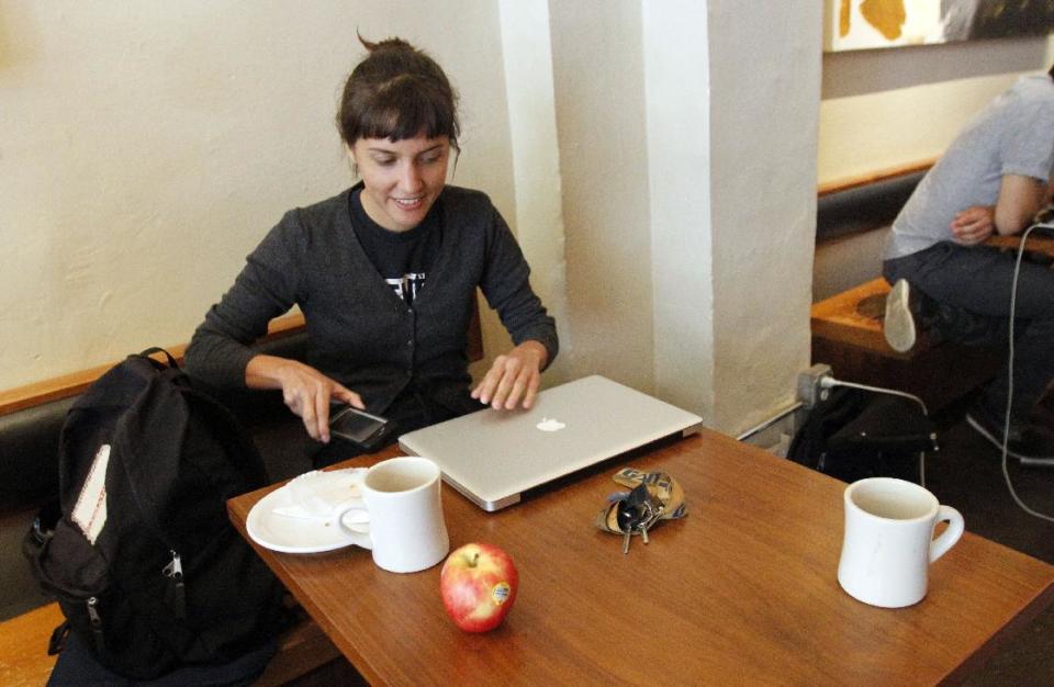 Deanna Horton sets up at a coffee shop in downtown Portland, Ore., Wednesday, Sept. 19, 2012. Researchers at Portland State University found that Portland is a magnet for the young and college educated, even though a disproportionate share of them are working in part-time jobs or positions that don’t require a college degree. (AP Photo/Don Ryan)