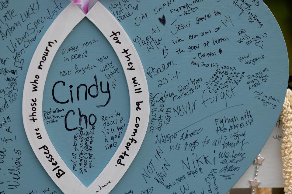 Messages are written on a cross set up in a memorial near the scene of a mass shooting at the Allen Premium Outlets mall on May 9, 2023, in Allen, Texas.