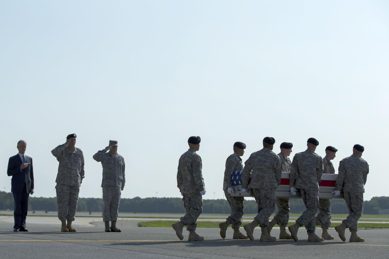 Army Secretary John McHugh, left, and Army Chief of Staff Ray Odierno, second from left, watch as an Army carry team transfers the remains of Army Maj. Gen. Harold Greene at Dover Air Force Base, Del., on Thursday, Aug. 7, 2014. Greene was killed in the Afghan conflict. (AP Photo/Evan Vucci)