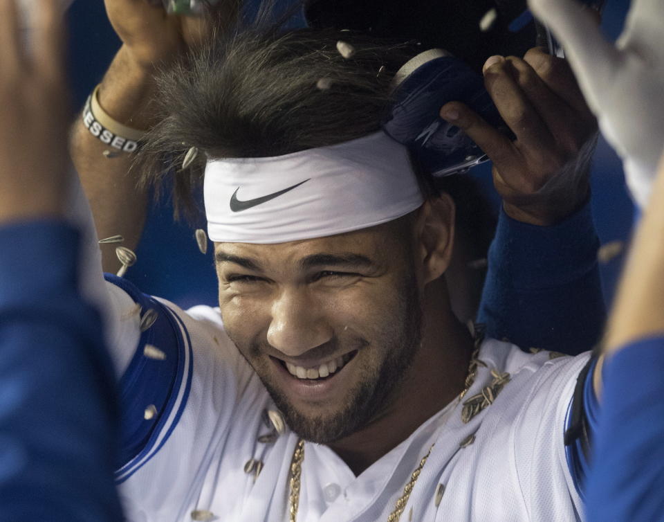 Toronto Blue Jays' Lourdes Gurriel Jr. gets a sunflower-seed shower in the dugout after hitting a solo home run against the Tampa Bay Rays during the first inning of a baseball game Friday, Sept. 21, 2018, in Toronto. (Fred Thornhill/The Canadian Press via AP)