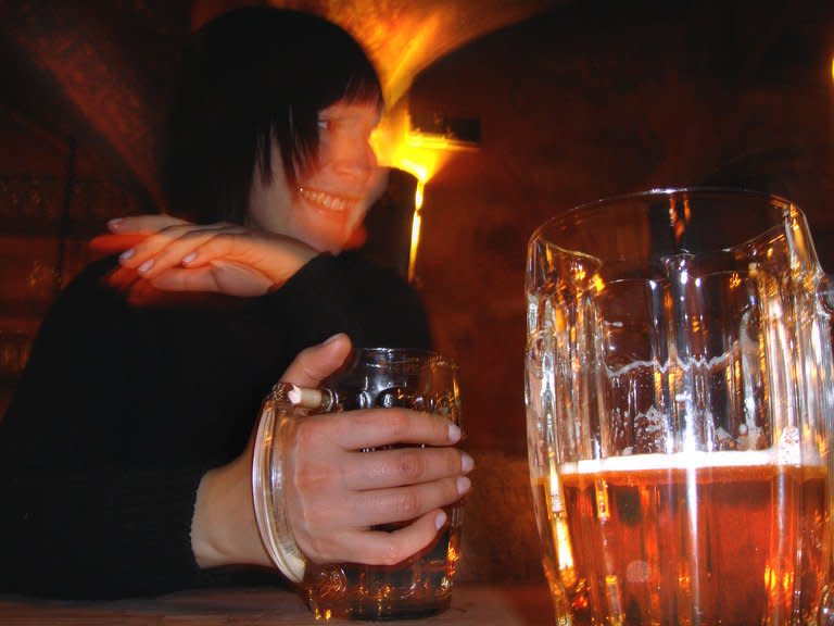 A woman holds a glass of beer in a Moscow bar. One Russian treatment for alcoholism involves under-the-skin implants of capsules containing a substance that allegedly produces negative physical effects if the patient drinks alcohol