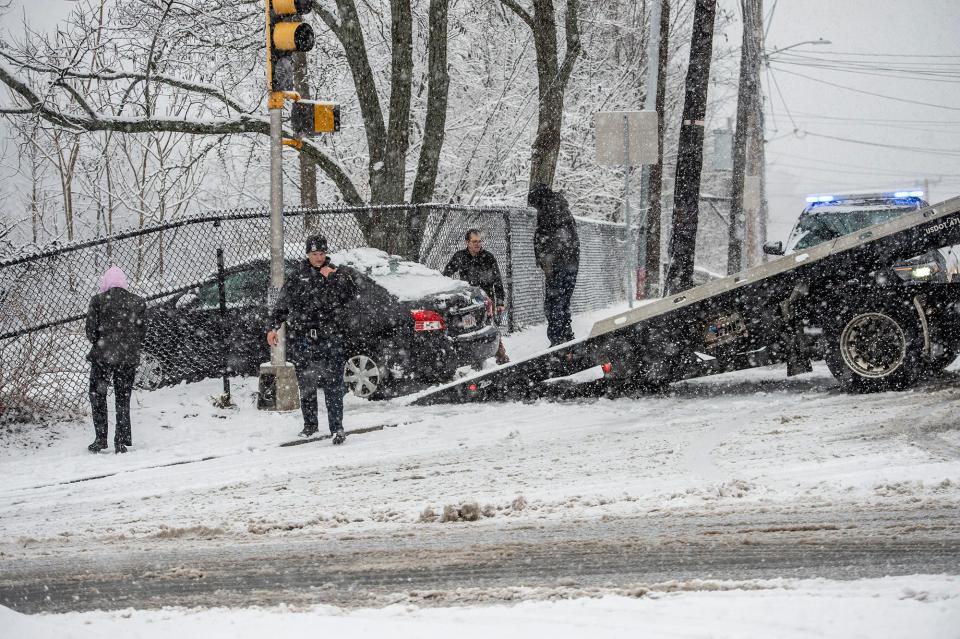 Framingham police officers and representatives from Henry's Towing were on the scene earlier today of a car that slid on the snow and went through a chain-link fence at Water and Central streets, with the Sudbury River a short distance away, Jan. 23, 2023. There were no injuries.