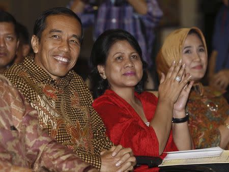 Indonesian President Joko "Jokowi" Widodo and his wife Iriana react as names are read out during their son's graduation ceremony at Anglo-Chinese School (ACS) International in Singapore in this November 21, 2014 file photo. REUTERS/Edgar Su/