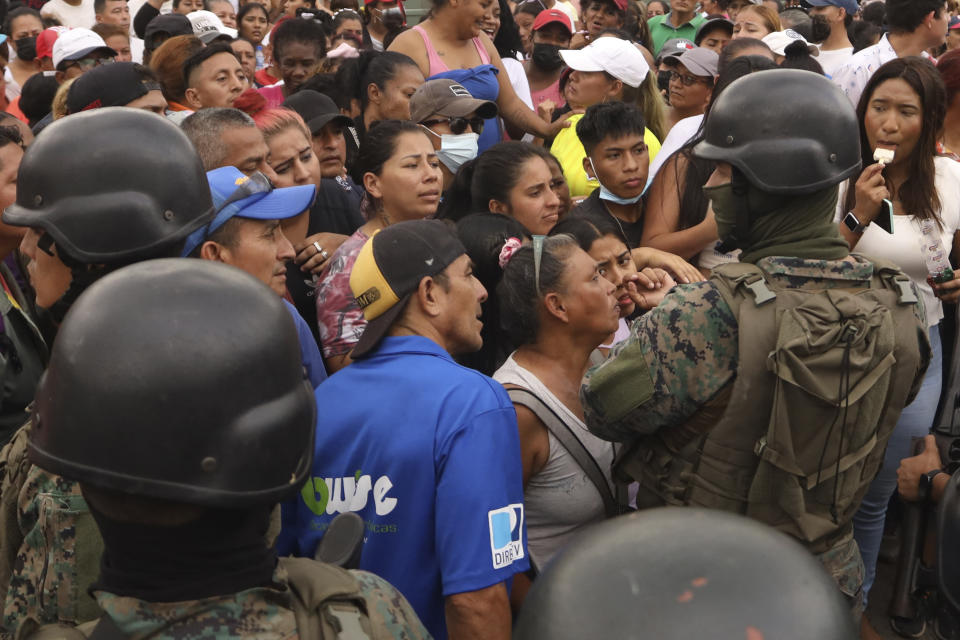 Amigos y familiares de presos esperan noticias de sus seres queridos tras los enfrentamientos con muertos en la Penitenciaría del Litoral de Guayaquil, Ecuador, el martes 25 de julio de 2023. Ecuador anunció el martes un estado de excepción en todo el sistema penitenciario después de una serie de violentos incidentes que incluyeron disparos y explosiones en la cárcel más grande y peligrosa del país. (AP Foto/César Muñoz)