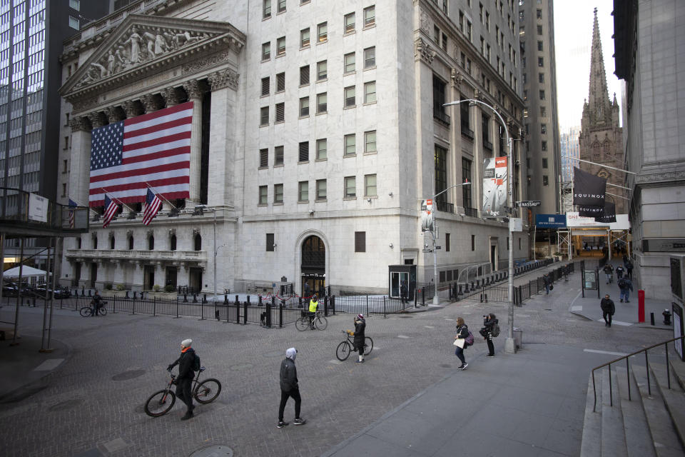 FILE - In this March 18, 2020, file photo a few people walk on Wall Street in front of the New York Stock Exchange in New York. When President Donald Trump speaks, financial markets gyrate and quiver in real time. (AP Photo/Mark Lennihan, File)