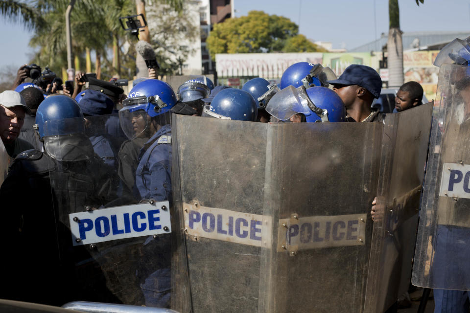 Riot police enter the Bronte hotel, where a press conference by opposition leader Nelson Chamisa was scheduled to take place, in Harare, Zimbabwe, Friday Aug. 3, 2018. Hours after President Emmerson Mnangagwa was declared the winner of a tight election, riot police disrupted a press conference where opposition leader Nelson Chamisa was about to respond to the election results. (AP Photo/Jerome Delay)