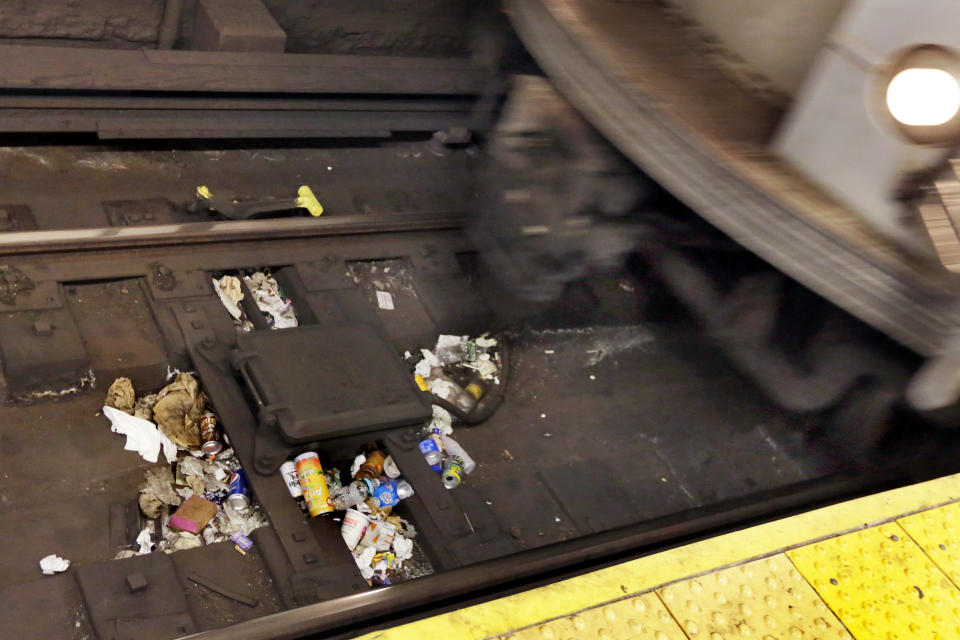 A subway train arrives in the Park Place station, passing over discarded trash on the tracks, in New York, Thursday, March 30, 2017. Faced with the problem of too much litter and too many rats in their subway stations, New York City transit officials began an unusual social experiment a few years ago. They removed trash bins entirely from select stations, figuring it would deter people from bringing garbage into the subway in the first place. This week, they pulled the plug on the program after reluctantly concluding that it was a failure. (AP Photo/Richard Drew)