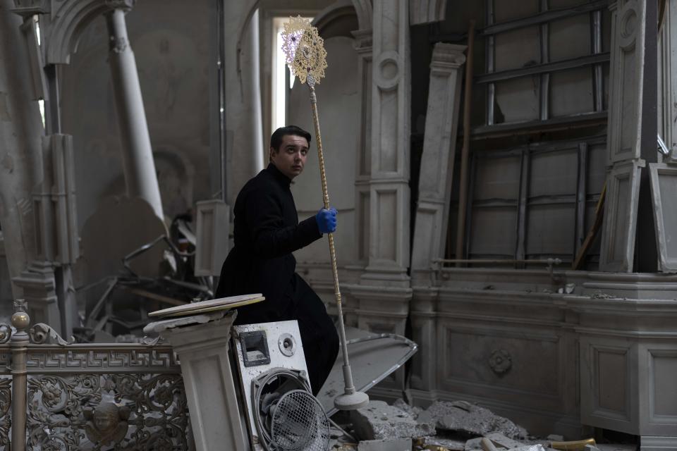 A church personnel salvages items while helping clean up inside the Odesa Transfiguration Cathedral after it was heavily damaged in Russian missile attacks in Odesa, Ukraine, Sunday, July 23, 2023. (AP Photo/Jae C. Hong)