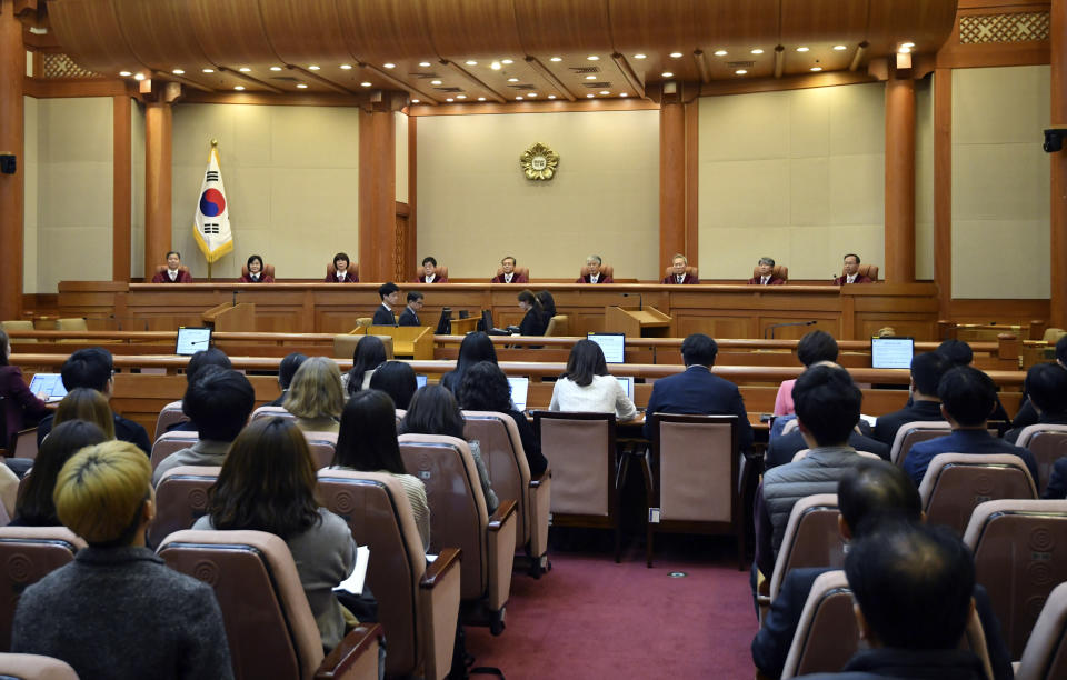 South Korea's Constitutional Court chief judge Yoo Nam-seok (C) and other judges sit for the ruling on decriminalization of abortion at the court in Seoul Thursday, April 11, 2019. South Korea's Constitutional Court has ruled that a decades-long ban on abortions is incompatible with the constitution, setting up a likely easing of restrictions. (Jung Yeon-je /Pool Photo via AP)