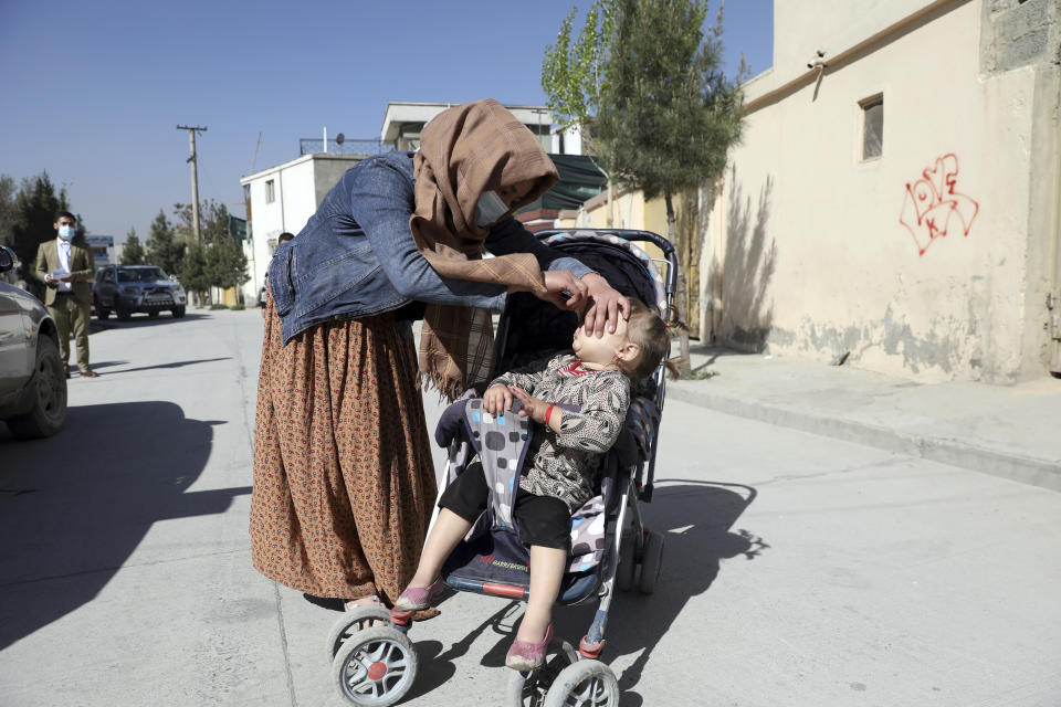 A health worker administers a polio vaccine to a child during a polio vaccination campaign in the city of Kabul, Afghanistan, Tuesday, March 30, 2021. (AP Photo/Rahmat Gul)