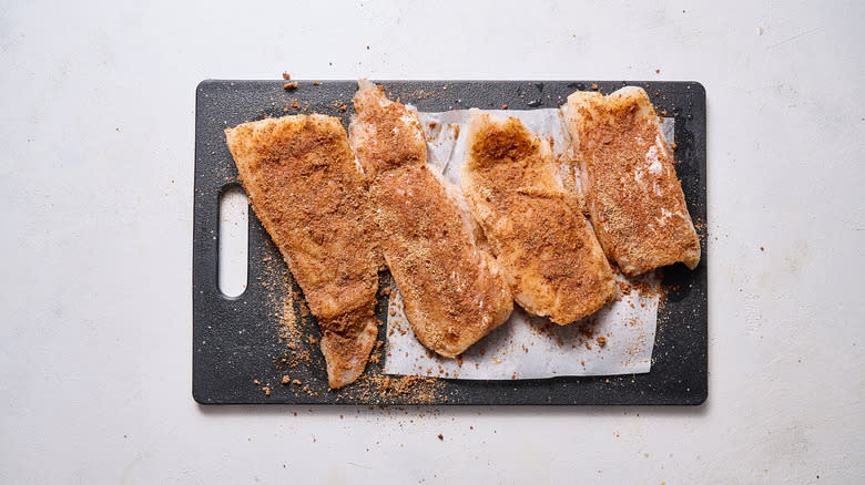 seasoning cod on cutting board