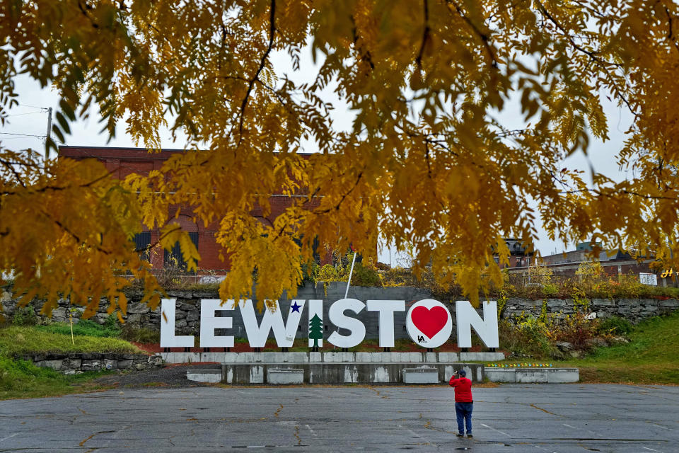 FILE - A man photographs a make-shift memorial at the base of the Lewiston sign at Veteran's Memorial Park, Oct. 29, 2023, in Lewiston, Maine. A lieutenant colonel with the Army Reserves says a reservist who would go on to commit the deadliest mass shooting in Maine history had a low threat profile when he left a psychiatric hospital prior to the killings. Lt. Col. Ryan Vazquez testified Monday, June 17, 2024 in front of a state commission investigating the Lewiston shootings to answer questions about what Army officials knew about shooter Robert Card prior to the Oct. 25 shootings. (AP Photo/Matt York, file)