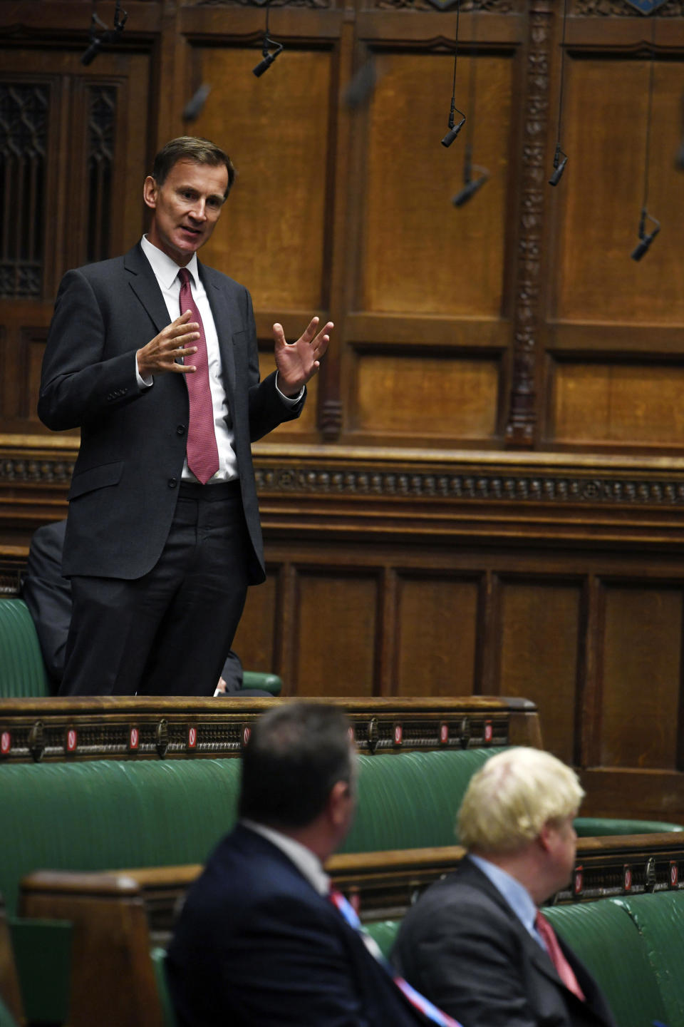 In this handout photo provided by UK Parliament, MP Jeremy Hunt responds after Prime Minister Boris Johnson delivered a statement in the House of Commons, London, Tuesday, Sept. 22, 2020. Johnson has warned Britons they should not expect to return to a normal social or work life for at least six months, as he announced new restrictions he hopes will suppress a surge in coronavirus cases. (Jessica Taylor/UK Parliament via AP)