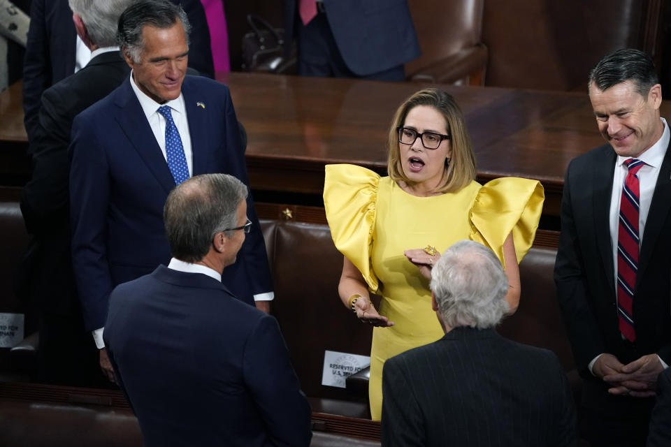 Sen. Kyrsten Sinema, Ind-Ariz., center, speaks with Sen. Mitt Romney, R-Utah, left, and Sen. Todd Young, R-Ind., right, and others, before President Joe Biden arrives to deliver his State of the Union speech to a joint session of Congress, at the Capitol in Washington, Tuesday, Feb. 7, 2023. (AP Photo/J. Scott Applewhite)