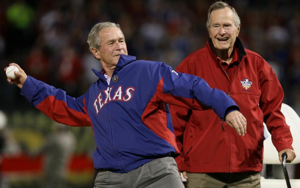 George W Bush throws out the first pitch in front of his father, George H W Bush, at the fouth game of the 2010 MLB World Series - Getty Images