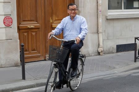 Former president of the dissolved opposition Cambodia National Rescue Party (CNRP) Sam Rainsy, who is living in exile, poses on his bicycle in Paris, France, July 19, 2018. REUTERS/Philippe Wojazer