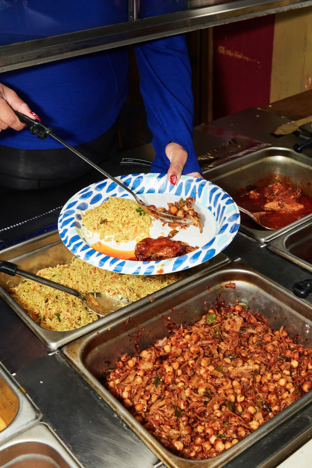 A diner loading up a plate with food from the buffet offerings