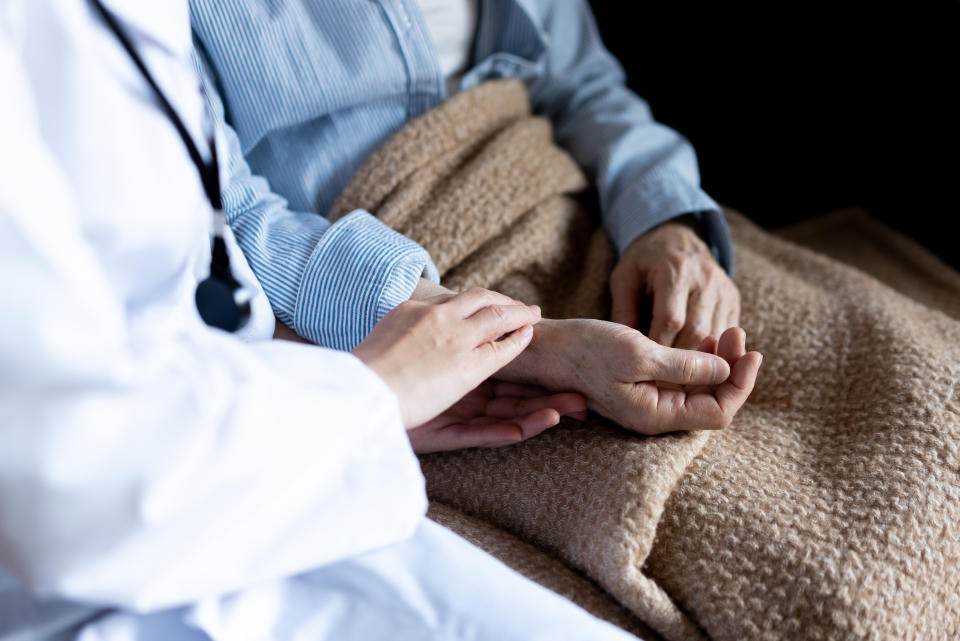 Home nursing care, home medical care.
I take the hand of the old woman sitting and measure her pulse.
Aging society.
An elderly woman is sitting on the sofa at home.