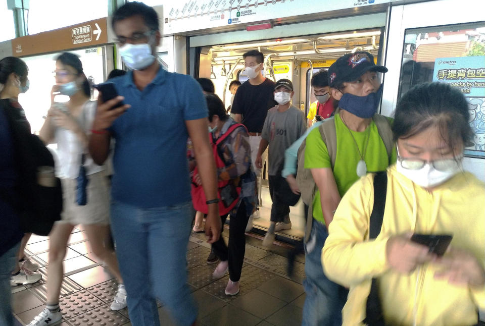Passengers, wearing face masks to protect against the spread of the coronavirus, get off a train in Taipei, Taiwan, Saturday, June 27, 2020. (AP Photo/Chiang Ying-ying)